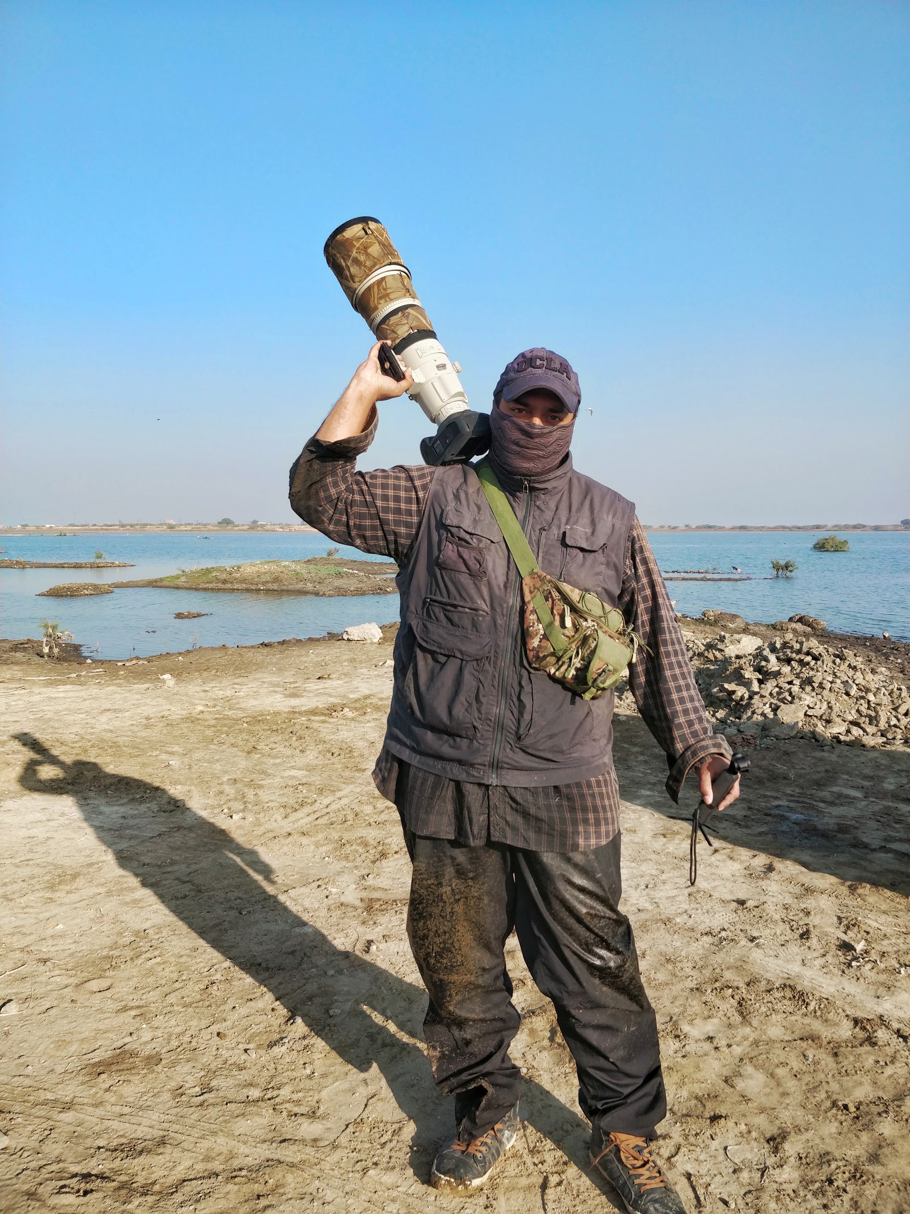 Filmmaker shooting handheld with a long lens in the field