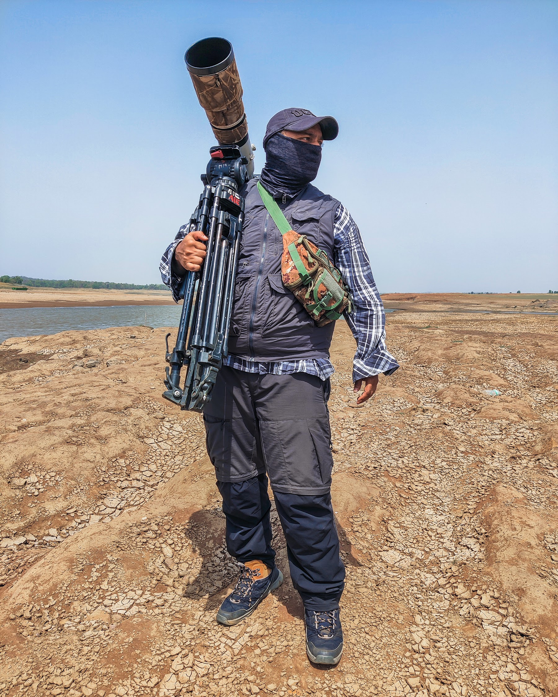 Filmmaker walking a hill trail with camera gear